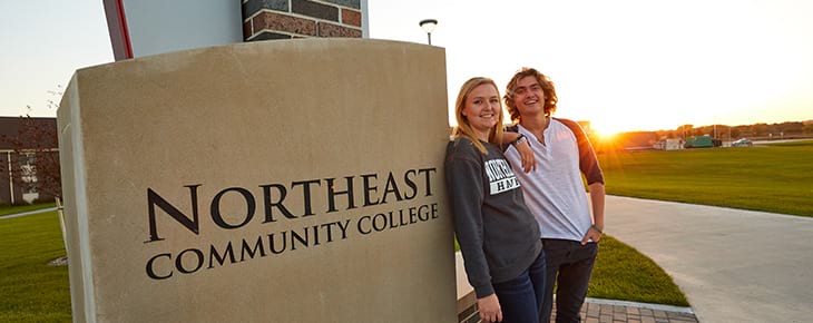 Students standing by Northeast sign